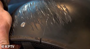 The biker's helmet cracked and covered in skid marks