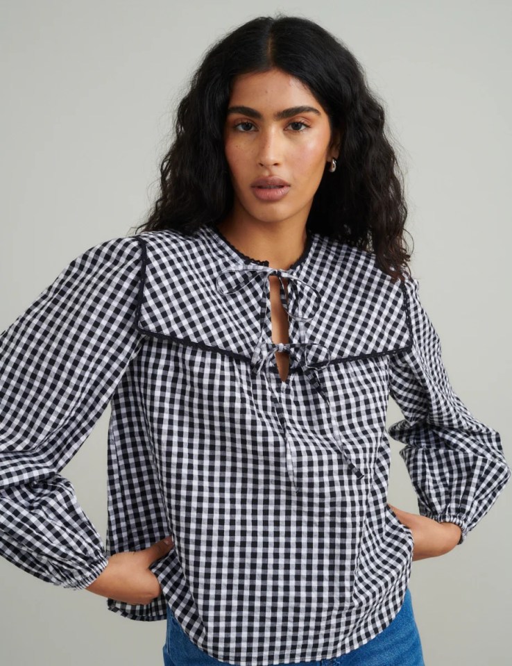 Woman wearing a black and white gingham blouse.