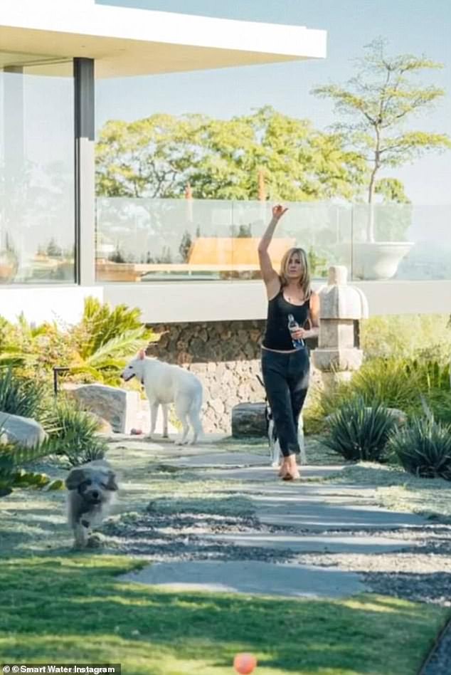 Aniston trekking through her backyard alongside her do