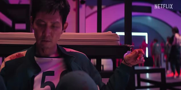 Players are also seen given mysterious red or blue boxes - which may correspond to their gumballs, while an intriguing shot shows Gi-hun handcuffed to a bunkbed