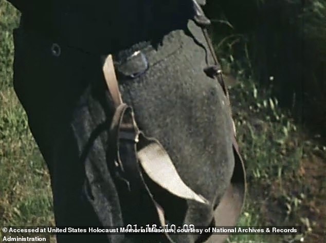 The camera pans down to the woman's trousers, with suspenders hanging down to her feet
