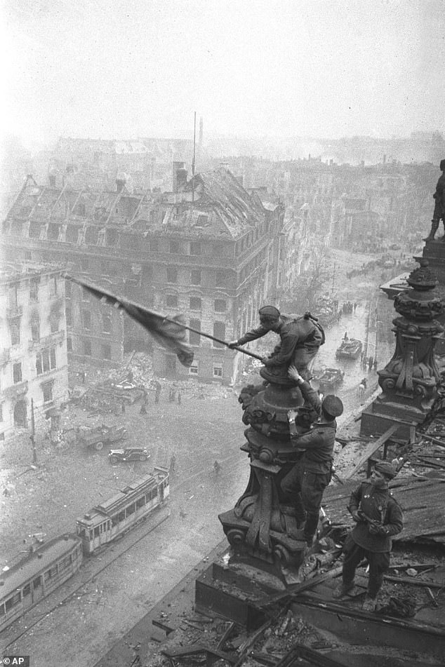 Berlin fell to Russian troops on May 2, 1945. Pictured: Soldiers planting the Soviet flag on the roof of the Reichstag
