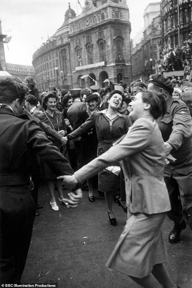 Pictured: Jubilant Londoners dancing in Piccadilly Circus on VE Day
