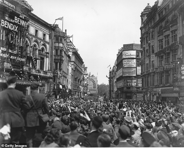 Pictured: Jubilant crowds at Piccadilly Circus, London, celebrating victory