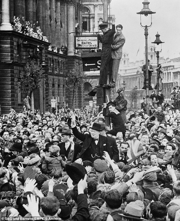Pictured: Winston Churchill is mobbed by the excited crowds as he made his triumphant ride to the Houses of Parliament after his victory speech which was relayed to the thousands in Whitehall
