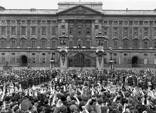 Pictured: A vast crowd assembles in front of Buckingham Palace to cheer Britain's Royal family minutes after the official announcement of Germany's unconditional surrender in World War II