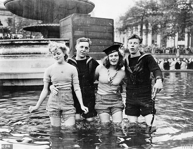 Pictured: Two British sailors in a fountain in Trafalgar Square, London, with Joyce Digney (left) and Cynthia Covello, members of the Land Army, who travelled to London to celebrate VE Day