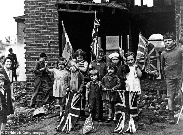 Pictured: Young children in bomb-scarred Battersea in south London with their Union Flags on May 8, 1945