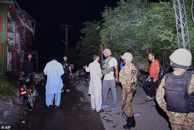 Security force officials and media gather outside a damaged building from a suspected Indian missile attack near Muzaffarabad, the capital of Pakistan controlled Kashmir, in Wednesday, May 7, 2025