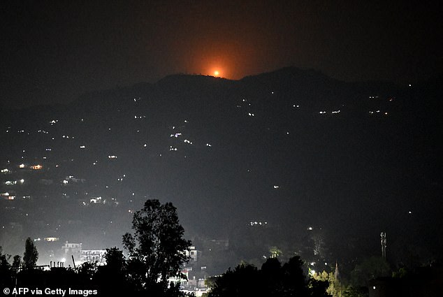 A flare goes up in air over the hill near main town of Poonch district