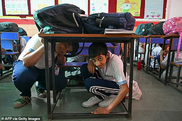Students take part in an emergency mock drill as part of the nationwide civil defence mock drill at a school in New Delhi on May 7, 2025, as border tensions surge