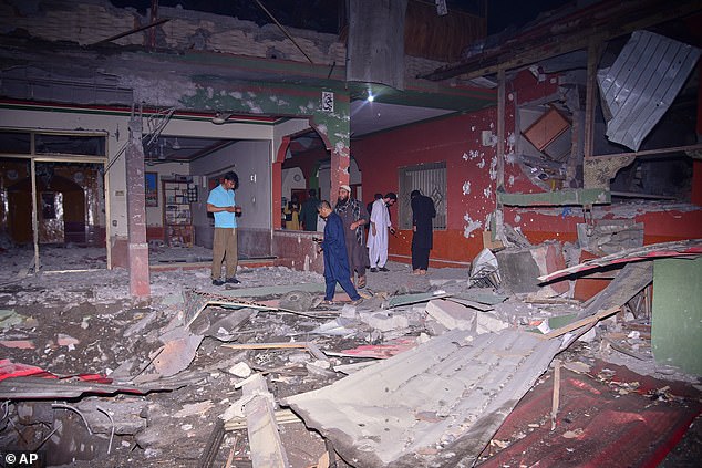 Local residents and members of the media examine a building damaged by a suspected Indian missile attack near Muzaffarabad, the capital of Pakistan controlled Kashmir, in Wednesday, May 7