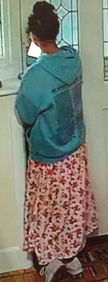 Image of a woman wearing a teal hoodie and a long pink and red patterned skirt.