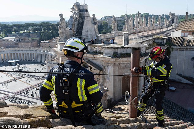 Firefighters install a chimney on the roof of the Sistine Chapel, ahead of the conclave, at the Vatican May 2, 2025