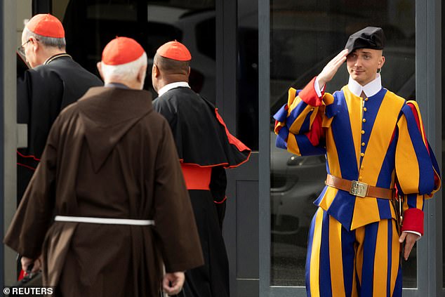 A Swiss guard salutes to cardinals arriving for a general congregation meeting ahead of the conclave at the Vatican to elect the next pope, as seen from Rome, Italy, May 5, 2025
