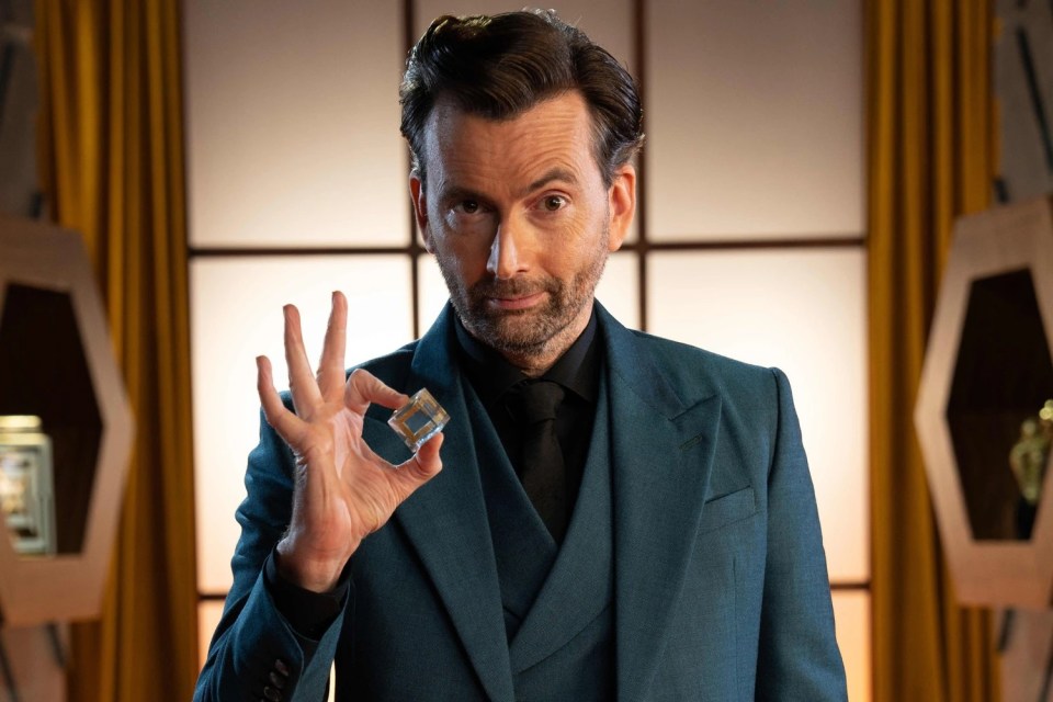 David Tennant holding a small, cube-shaped object.