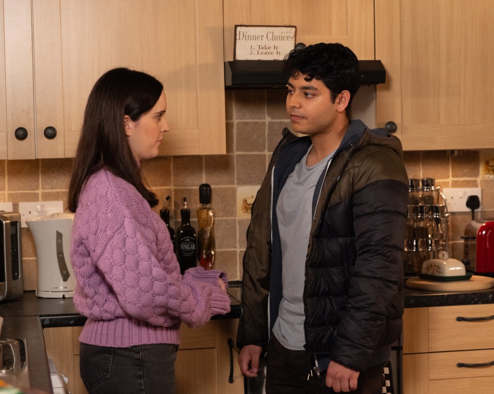 Aadi Alahan and Amy Barlow in a kitchen, looking at each other.