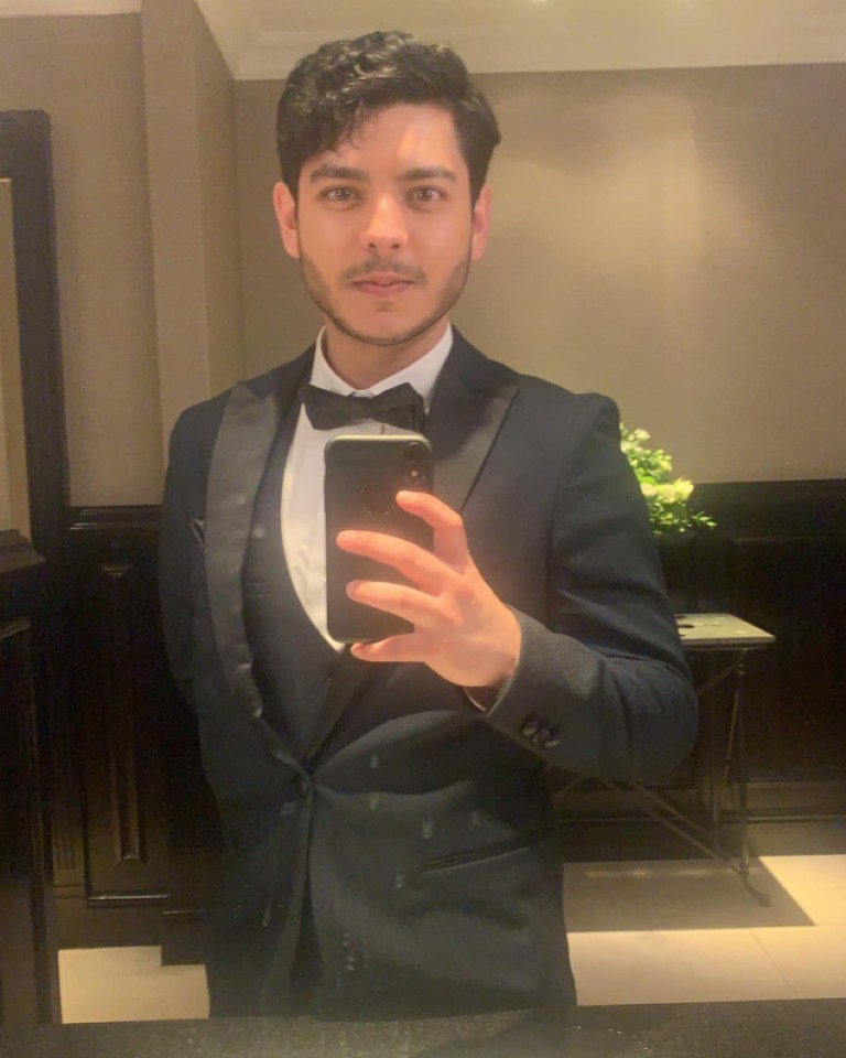 Man in tuxedo taking a selfie.