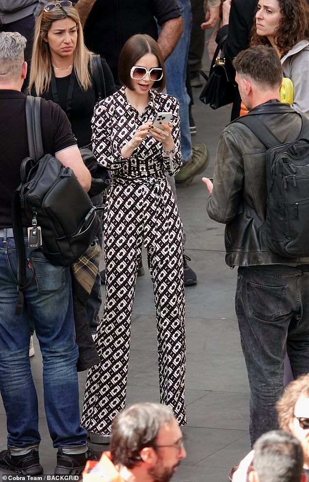 Emily looked typically chic in a black and white geometric print jumpsuit which was belted around her waist and styled with towering silver platforms