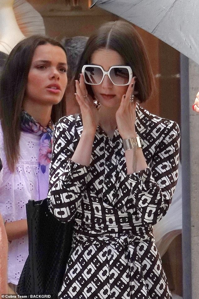 She added a pair of huge white square shades to the outfit