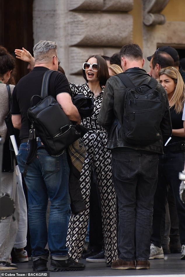 In between takes, Lily was seen warming greeting members of the team