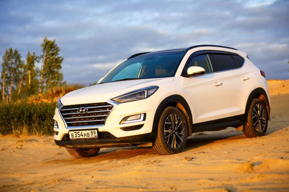 White Hyundai Tucson on a sandy surface.
