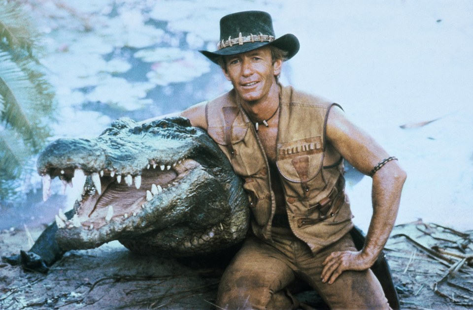Paul Hogan with a crocodile in a scene still from *Crocodile Dundee*.