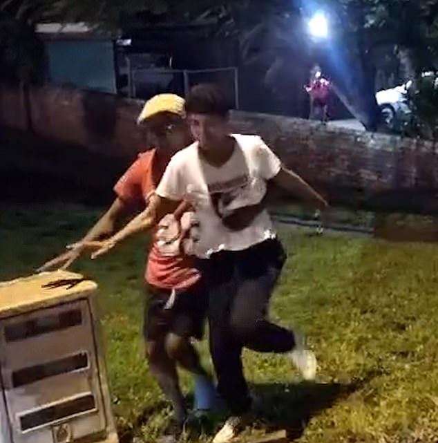 The cameraman shouts, 'You're stupid' as the stunned woman gets to her feet and staggers away, leaning on a man for support