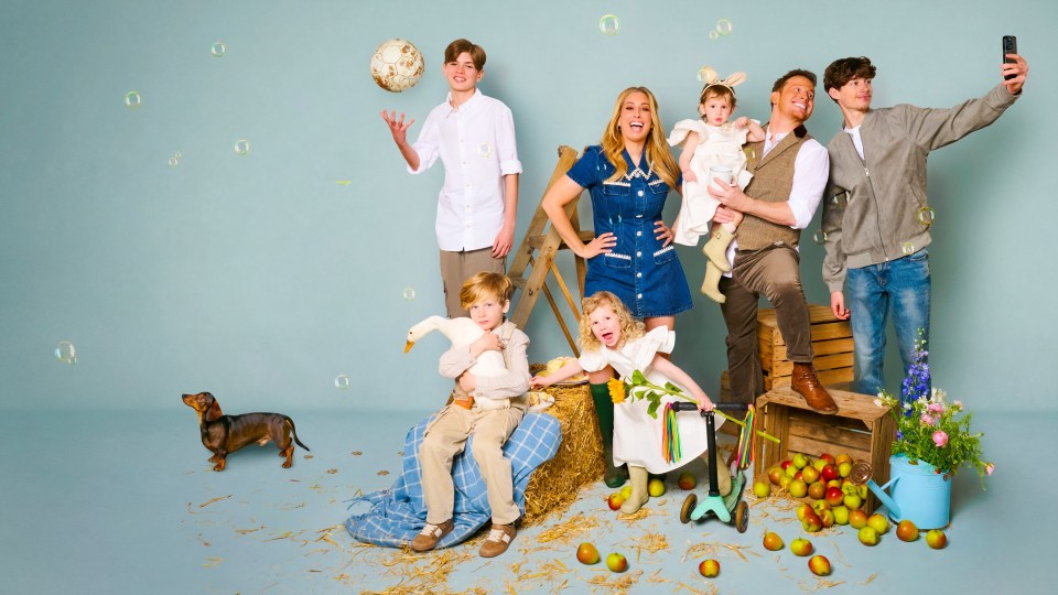 Family portrait with children, dog, and farm props.