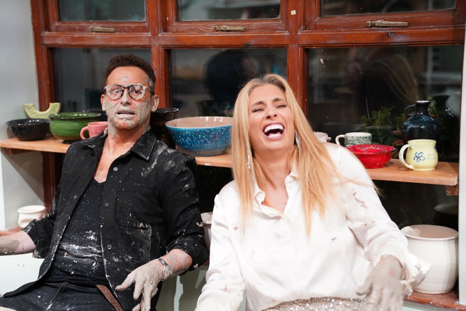Joe Swash and Stacey Solomon covered in clay, laughing.