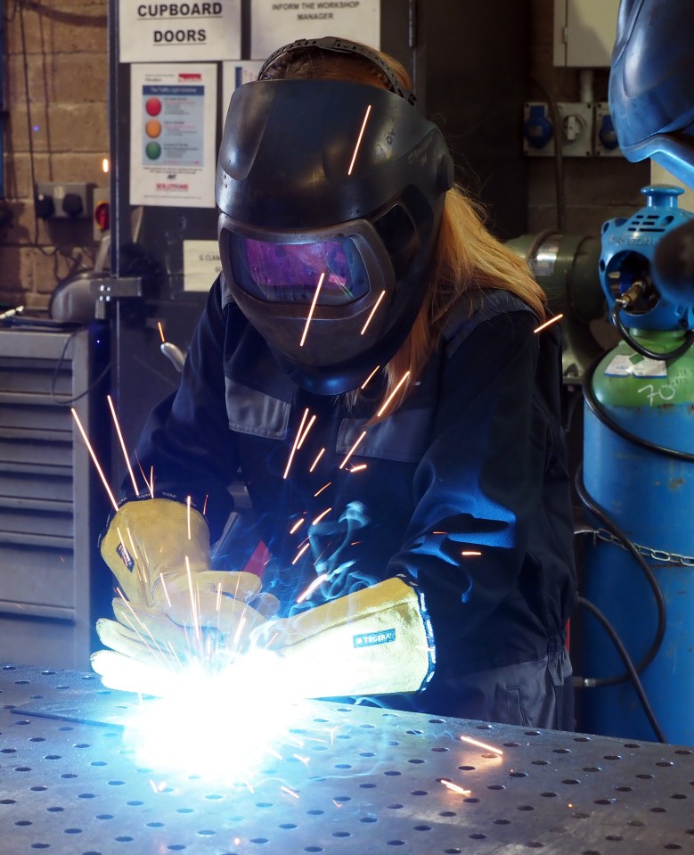 Woman welding metal.