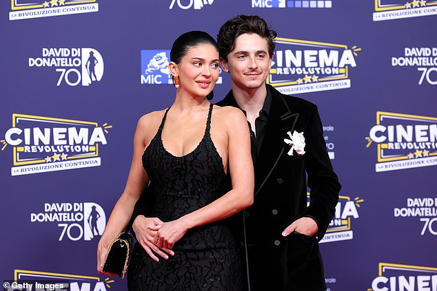 While 'not many women appreciate having a hand placed on their stomach in the way that he's doing here' Kylie didn't seem to mind as she added 'an approval gesture by placing her own hand on top of his and inclining her head backwards to look like a woman in love'