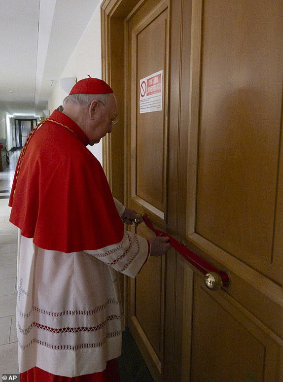 This image distributed by Vatican Media on Tuesday, April 22, 2025, shows Cardinal Camerlengo Kevin Joseph Farrell sealing Pope Francis's private apartment inside the 'Domus Sanctae Marthae' hotel at the Vatican. (Vatican Media via AP, HO)
