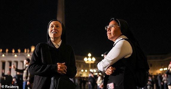 Faithful react to black smoke rising from the chimney on the Sistine Chapel indicating no decision has been made to elect a new pope, at the Vatican, May 7, 2025. REUTERS/Marko Djurica