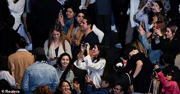 People react as black smoke rises from the chimney on the Sistine Chapel, indicating no decision has been made to elect a new pope, at the Vatican, May 7, 2025.  REUTERS/REMO CASILLI