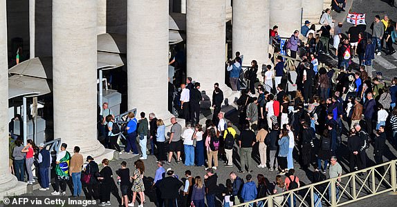 Visitors queue for security checks under the colonnade to enter The Vatican's St Peter's Square during the conclave, in Rome on May 7, 2025. The doors of the Sistine Chapel closed on May 7, 2025, signalling the beginning of the conclave in which 133 cardinals will elect the successor to Pope Francis, according to a live video broadcast by the Vatican. (Photo by Andrej ISAKOVIC / AFP) (Photo by ANDREJ ISAKOVIC/AFP via Getty Images)