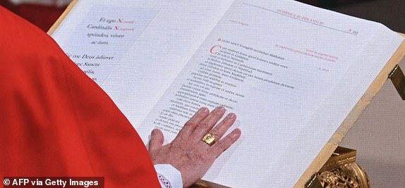 Faithful watch a giant screen displaying  the holy mass of cardinals to the Sistine chapel, at St Peter's Square on the first day of the conclave to elect the next pope, at the Vatican, on May 7, 2025. (Photo by Stefano Rellandini / AFP) (Photo by STEFANO RELLANDINI/AFP via Getty Images)