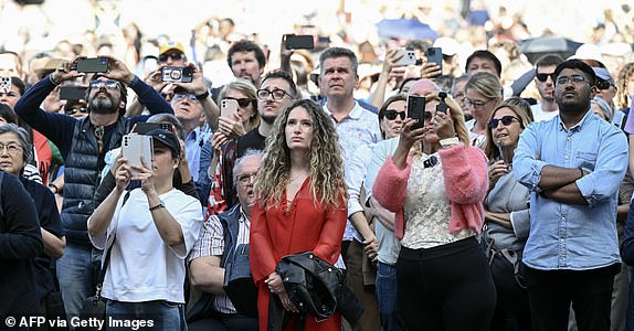 Faithful watch a live broadcast on giant screens on St Peter's Square ahead of the conclave to elect the next pope at the Vatican, on May 7, 2025. (Photo by Stefano Rellandini / AFP) (Photo by STEFANO RELLANDINI/AFP via Getty Images)