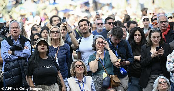 Faithful watch  on St Peter's Square ahead of the conclave to elect the next pope at the Vatican, in The Vatican, on May 7, 2025. (Photo by Stefano Rellandini / AFP) (Photo by STEFANO RELLANDINI/AFP via Getty Images)