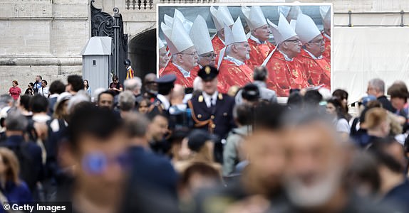 VATICAN CITY, VATICAN - MAY 07: People gather in St. Peter's Square as the Mass for the Election of the New Pope is shown on screens before the start of the conclave on May 07, 2025 in Vatican City, Vatican. Cardinals of the Catholic Church have descended on Vatican City to commence the papal conclave, the secretive voting process held in the Sistine Chapel that requires a two-thirds majority to elect the new leader of the Catholic Church. The election follows the death of Pope Francis on April 21 at the age of 88. (Photo by Mario Tama/Getty Images)