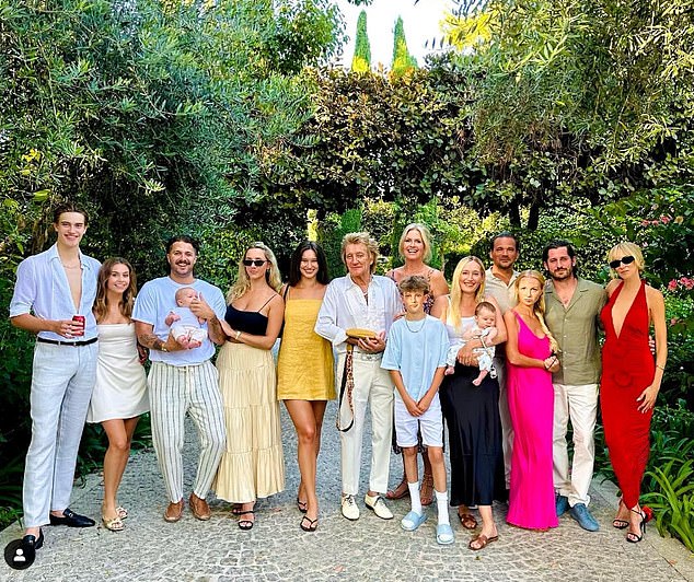 The Maggie May hitmaker has eight children with five different women, two of whom are sons Alastair and Aidan which he raises with third wife Penny [pictured with seven of his eight children and three grandchildren]