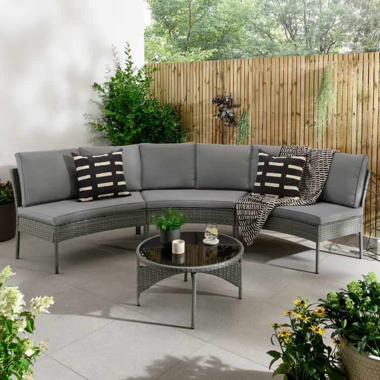 Grey curved outdoor sofa set with coffee table.