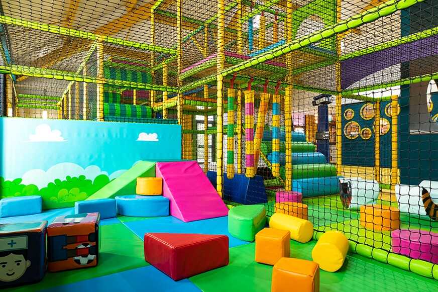 Colorful indoor playground with soft play equipment.