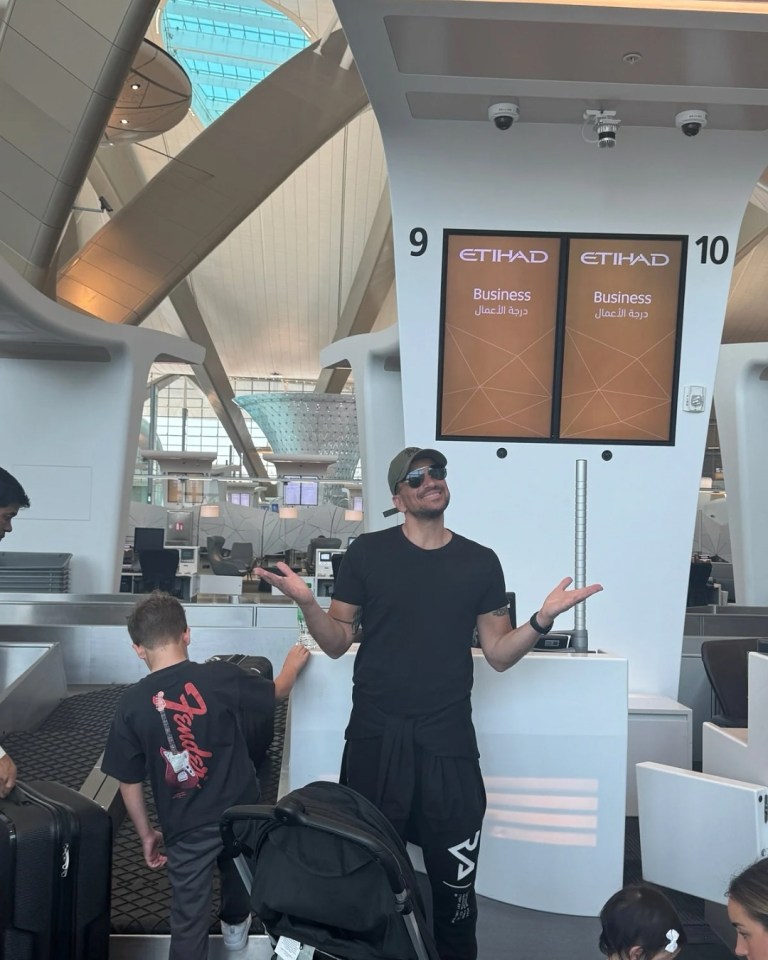 Man at airport check-in with family.