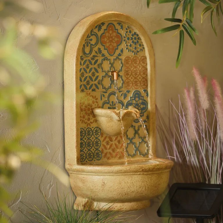 Wall-mounted fountain with patterned tile design.