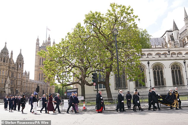 MPs and peers walk in procession from the Palace of Westminster to Westminster Abbey today