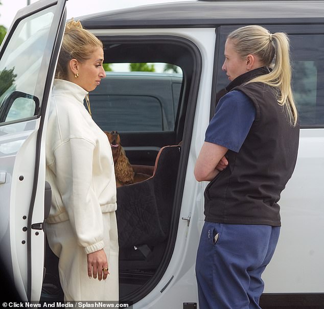 Stacey placed Teddy into the car as she continued to listen to what the vet had to say