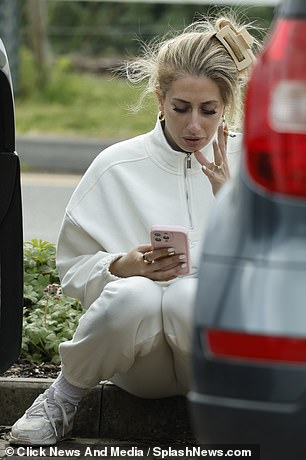 Appearing deep in thought, she lit up a cigarette and spent time on her phone