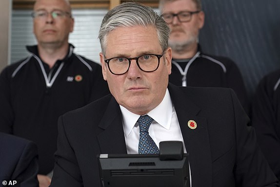 Britain's Prime Minister Keir Starmer speaks on the phone to US President Donald Trump at a car factory in the West Midlands, Thursday, May 8, 2025.(AP Photo/Alberto Pezzali, Pool)