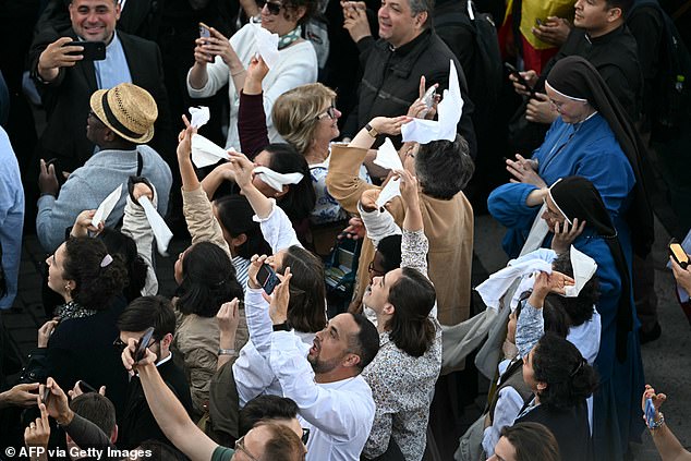 People react as white smoke (unseen) signals that cardinals elected a new pope
